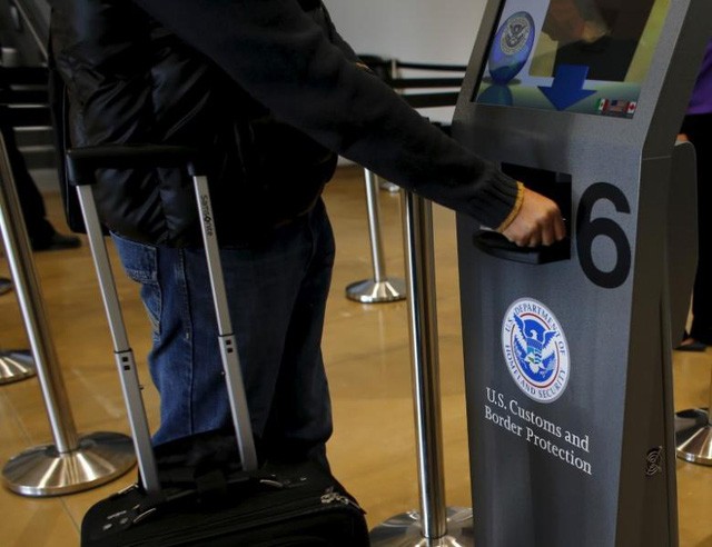 Khách du lịch quét hộ chiếu khi đi qua khu vực kiểm tra của Hải quan Mỹ (Ảnh: Reuters)