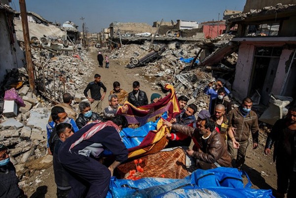 Cư dân quận al-Jadida thu gom các thi thể sau vụ không kích. Ảnh:Iraq News.
