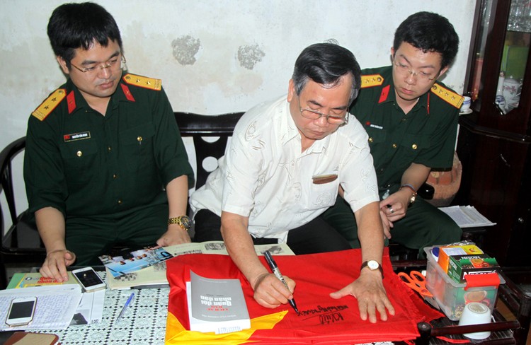 Nhà báo Nguyễn Khắc Xuể ký tặng lên lá Quốc kỳ gửi bộ đội Trường Sa