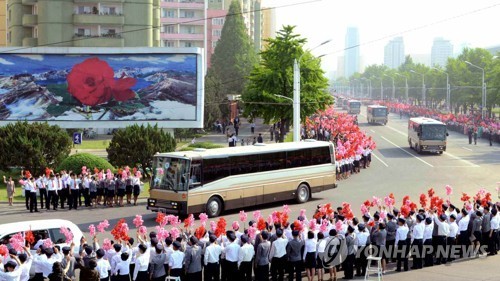 Người dân Triều Tiên vẫy cờ, hoa chào đón các nhà khoa học tên lửa được mời về thủ đô Bình Nhưỡng hôm 18/5 (Ảnh: KCNA)