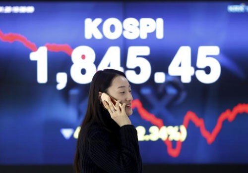 Một phụ nữ nói chuyện điện thoại trước tấm biển điện tử chạy chỉ số chứng khoán KOSPI ở Sở chứng khoán Hàn Quốc tại thủ đô Seoul ngày 21/1/2016. Ảnh:Reuters.