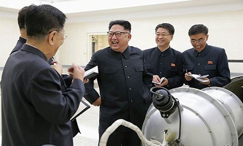 Lãnh đạo Triều Tiên Kim Jong-un tươi cười bên cạnh một thiết bị được cho là bom nhiệt hạch. Ảnh:KCNA.