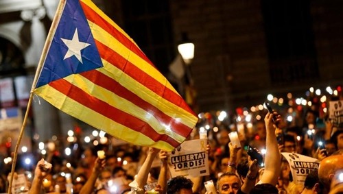 Người dân cầm nến và cờ Estelada ủng hộ Catalonia ly khai khỏi Tây Ban Nha, trong cuộc biểu tình tại Barcelona, phản đối việc bắt hai thủ lĩnh ủng hộ ly khai. Ảnh:AFP.