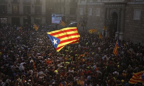 Người dân Catalonia vẫy cờ ăn mừng bên ngoài nghị viện ở thành phố Barcelona, sau khi nghị quyết tách khỏi Madrid được thông qua. Ảnh:AP.