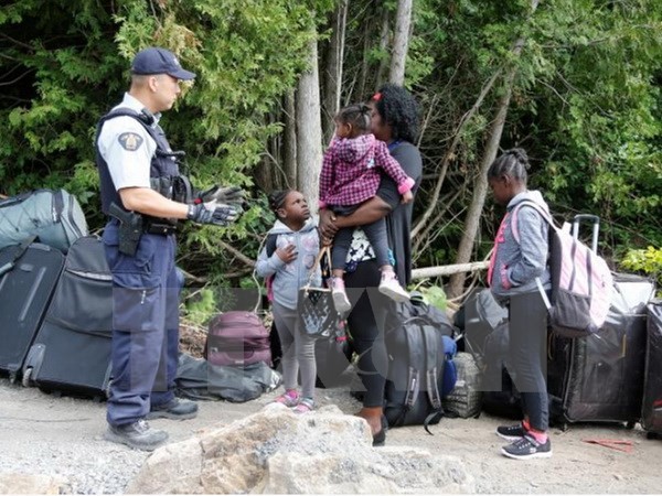 Cảnh sát Hoàng gia Canada kiểm tra một gia đình người tị nạn Haiti vào Canada từ Champlain, New York. (Nguồn: Reuters/TTXVN)