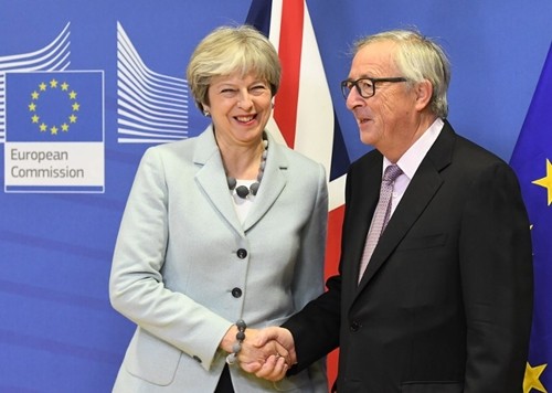 Thủ tướng Anh Theresa May bắt tay Chủ tịch Ùy ban châu Âu Jean-Claude Juncker trong cuộc gặp ngày 8/12 tại Brussels, Bỉ. Ảnh: AFP.