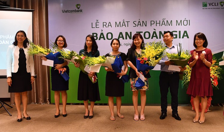 Bà Đoàn Hồng Nhung - Trưởng phòng Quản lý Bán sản phẩm bán lẻ, Thành viên HĐTV Công ty VCLI (thứ 2 từ phải sang) và bà Young Lai Yin - Tổng giám đốc VCLI (ngoài cùng bên trái) tặng hoa chúc mừng các khách hàng tham gia sản phẩm Bảo an Toàn gia