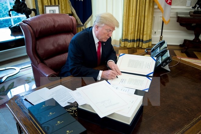 Tổng thống Mỹ Donald Trump ký một văn bản ở Washington DC., ngày 22/12/2017. (Ảnh: AFP/TTXVN)