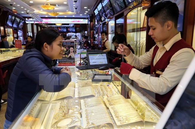 Mua bán vàng tại cửa hàng của Công ty Vàng bạc Bảo Tín Minh Châu, phố Trần Nhân Tông, quận Hai Bà Trưng, Hà Nội. (Ảnh: Trần Việt/TTXVN)