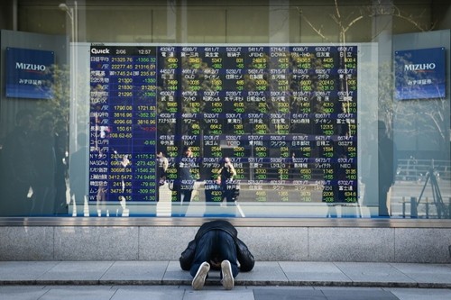 Phản ứng của một người Nhật khi nhìn bảng điện tử chứng khoán sáng nay. Ảnh:Bloomberg