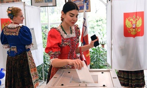 Một cô gái trong trang phục dân tộc Nga đi bỏ phiếu ở Sochi hôm 18/3. Ảnh: RT.