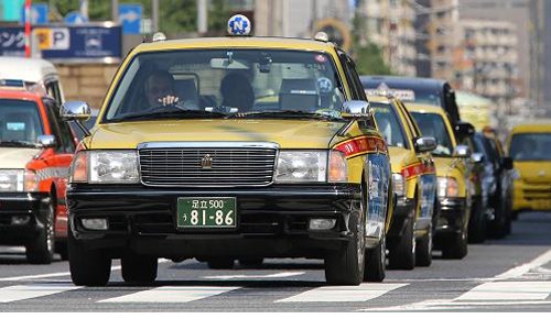 Các xe taxi dừng đèn đỏ trên đường phố Tokyo. Ảnh:Bloomberg.