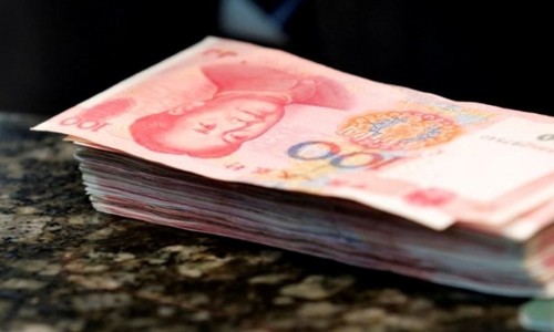Các tờ 100 NDT trên quầy giao dịch tại một ngân hàng ở Bắc Kinh. Ảnh:Reuters