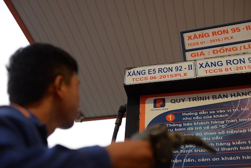 Nhân viên cây xăng tại TP HCM xem bảng giá trước khi bơm xăngcho khách.Ảnh: Hữu Khoa