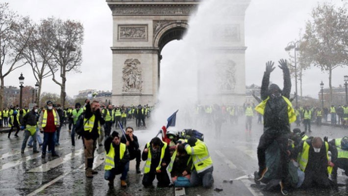 Biểu tình dưới chân Khải hoàn môn ở Paris hôm 1/12 - Ảnh: Reuters.
