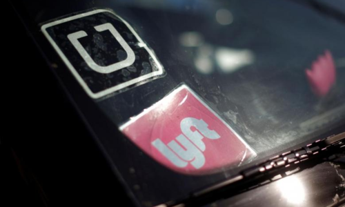 Logo của Uber và Lyft trên một xe hơi tại Mỹ. Ảnh:Reuters