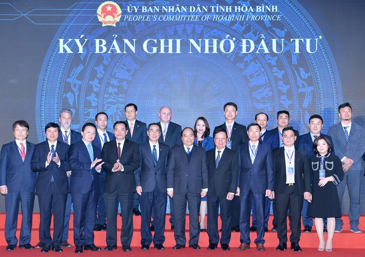 Thủ tướng Nguyễn Xuân Phúc chứng kiến lãnh đạo tỉnh Hòa Bình trao quyết định đầu tư, ký kết bản ghi nhớ đầu tư với các doanh nghiệp. Ảnh: Hiếu Nguyễn