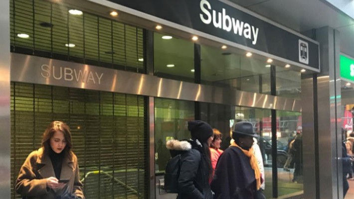 Hành khách đứng ngoài một nhà ga tàu điện ngầm ở Toronto, Canada, sau khi nhà ga này nhận được lời đe dọa đánh bom ngày 13/12 - Ảnh: Reuters.