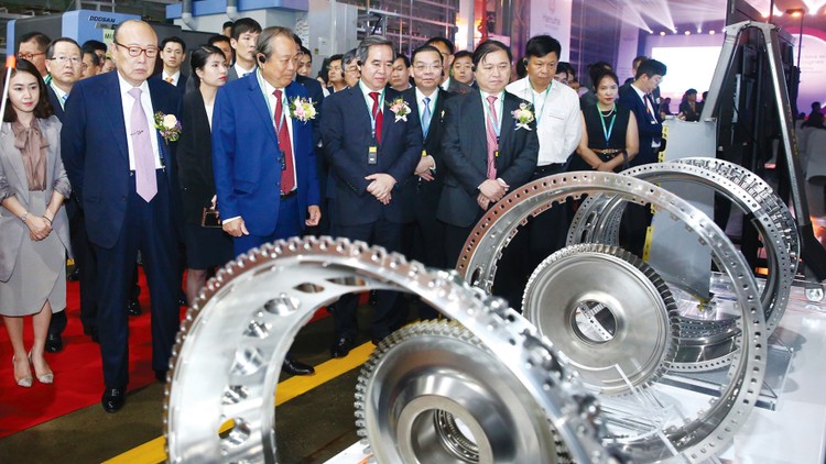 Phó Thủ tướng Trương Hòa Bình cùng các đại biểu tham quan dây chuyền sản xuất của Nhà máy Hanwha Aero Engines tại Khu công nghệ cao Hòa Lạc. Ảnh: Lê Tiên