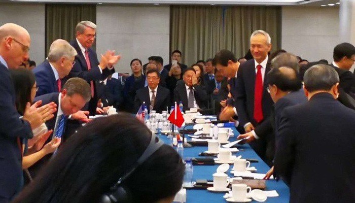Bức ảnh đăng trên tài khoản Twitter của tờ Wall Street Journal cho thấy Phó thủ tướng Trung Quốc Lưu Hạc (đứng bên phải, cà vạt đỏ) ghé vào phòng đàm phán - Ảnh: Twitter.