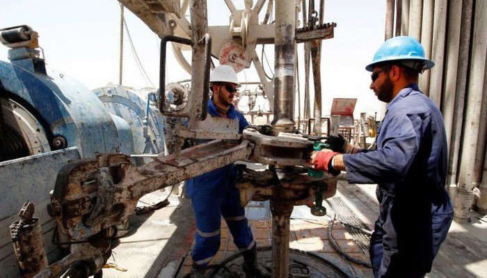 Công nhân làm việc trên một mỏ dầu ở Basra, Iraq - Ảnh: Reuters.