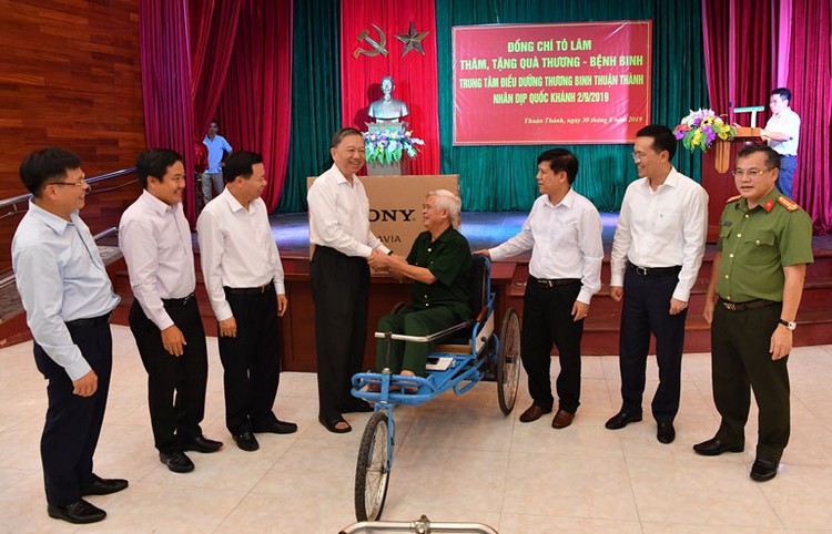 Đại tướng Tô Lâm (thứ 4 từ trái sang) cùng Tổng giám đốc Vietcombank Phạm Quang Dũng (thứ 2 từ phải sang) thăm hỏi và tặng quà đại diện các đồng chí thương binh. Ảnh: Lê Hồng Quang