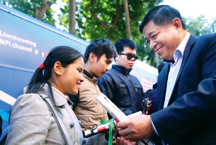 Bộ trưởng Bộ Kế hoạch và Đầu tư Nguyễn Chí Dũng trao gậy trắng cho người khiếm thị. Ảnh: Lê Tiên