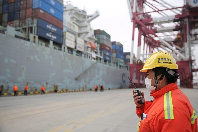 Quản đốc đeo khẩu tranglàm việc trước một tàu chở hàng cập cảngThanh Đảo, tỉnh Sơn Đông, Trung Quốc hôm 4/2.Ảnh: Reuters