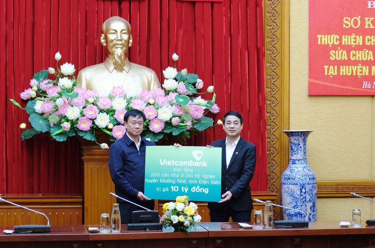 Chủ tịch HĐQT Ngân hàng TMCP Ngoại thương Việt Nam Nghiêm Xuân Thành (bên phải) trao biển tượng trưng 10 tỷ đồng hỗ trợ xây dựng, sửa chữa nhà cho 200 hộ nghèo tại huyện Mường Nhé, tỉnh Điện Biên