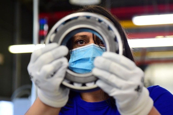 Công nhân trong một nhà máy đang xem xét sản phẩm vòng bi kim loại tại Italy. Ảnh: Reuters