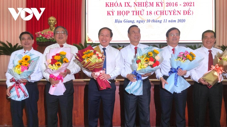 Ông Trần Văn Huyến (thứ hai từ phải qua) và ông Đồng Văn Thanh (bìa trái) nhận hoa chúc mừng.