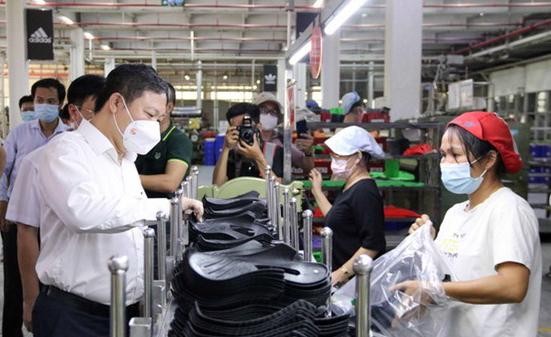 Phó Chủ tịch UBND Thành phố Hồ Chí Minh Dương Anh Đức thăm hỏi công nhân tại các chuyền sản xuất của Công ty Trách nhiệm hữu hạn Pouyuen Việt Nam ở quận Bình Tân. Ảnh: TTXVN
