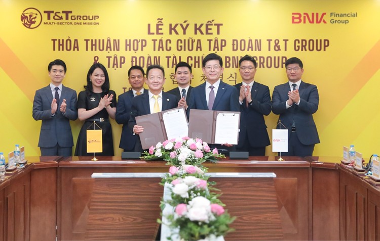 Ông Đỗ Quang Hiển, Chủ tịch UBCL Tập đoàn T&T Group (bên trái) và ông Bin Dae-in, Chủ tịch HĐQT kiêm TGĐ Tập đoàn Tài chính BNK (bên phải) trao thỏa thuận hợp tác với sự chứng kiến của đại diện lãnh đạo hai Tập đoàn. Nguồn ảnh: T&T Group