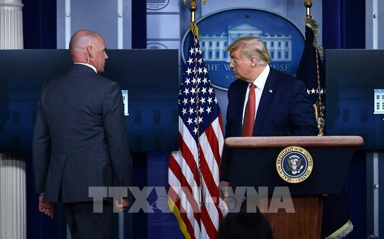 Mật vụ Mỹ hộ tống Tổng thống Donald Trump (phải) rời khỏi buổi họp báo tại Nhà Trắng khi xảy ra vụ nổ súng, ngày 10/8/2020. Ảnh: AFP/TTXVN