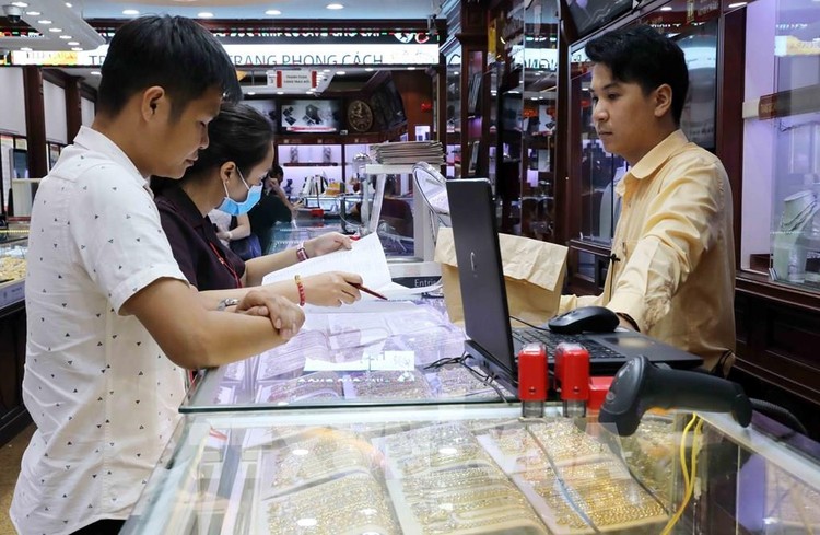 Khách mua bán vàng tại Công ty Kinh doanh vàng bạc Bảo Tín Minh Châu. Ảnh: Trần Việt - TTXVN