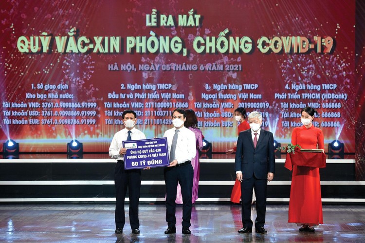 Ông Nghiêm Xuân Thành, Bí thư Đảng ủy, Chủ tịch HĐQT Vietcombank (thứ 2 từ trái sang) trao biển ủng hộ 60 tỷ đồng cho Quỹ Vắc-xin phòng, chống Covid-19