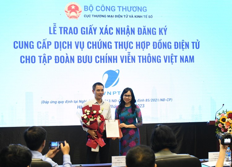 Bà Lê Hoàng Oanh - Cục trưởng Cục thương mại điện tử và Kinh tế số trao giấy xác nhận đăng ký cung cấp dịch vụ chứng thực hợp đồng điện tử cho đại diện Tập đoàn VNPT