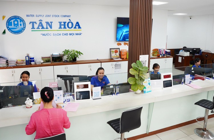 Nhân viên Công ty CP Cấp nước Tân Hòa hỗ trợ khách hàng đến giao dịch