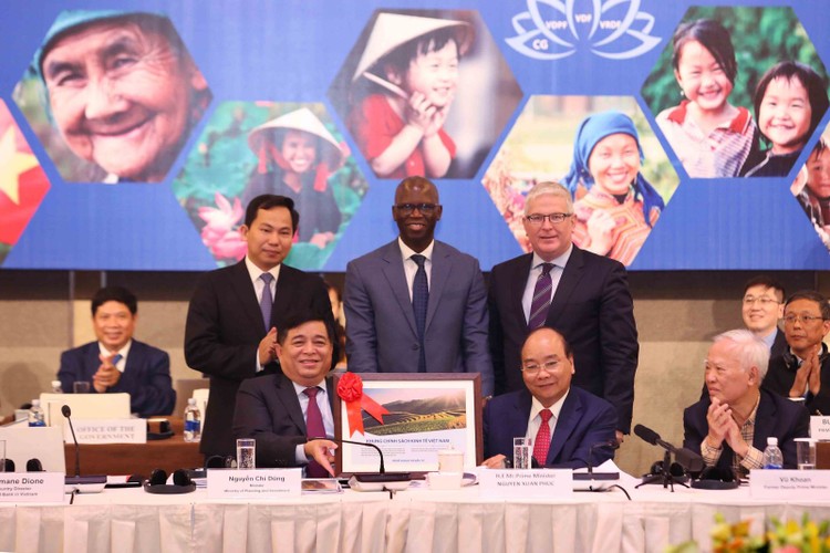 Bộ trưởng Nguyễn Chí Dũng trao cho Thủ tướng Chính phủ Nguyễn Xuân Phúc Khung chính sách kinh tế Việt Nam tại VRDF 2018. Ảnh: MPI
